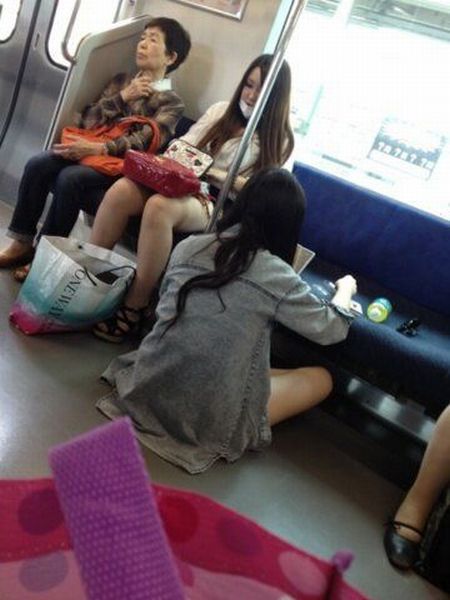 電車内でメイクする少女
